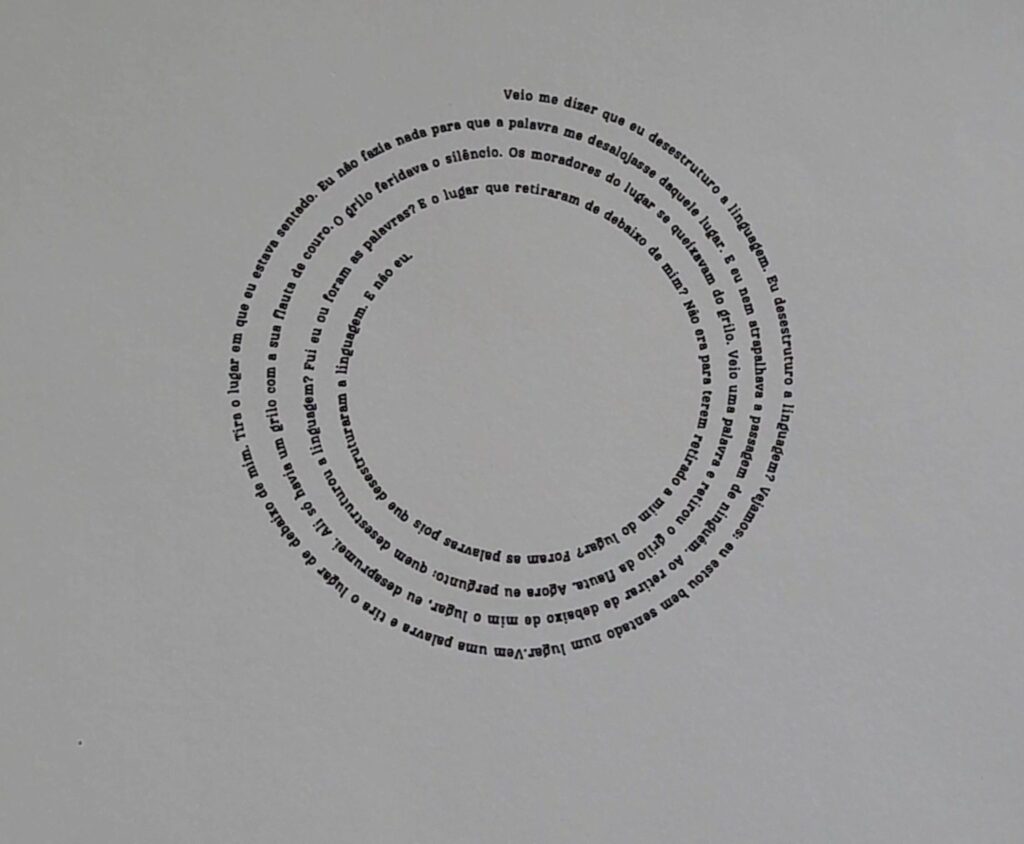 1. Palavras. A primeira imagem é intitulada “Palavras”, ela expressa o poema “Palavras” de Manoel de Barros num fundo branco com letras pretas pequenas em forma espiralar, começando de fora e terminando por dentro. Ao todo são quatro linhas espiraladas, espaçadas entre si.